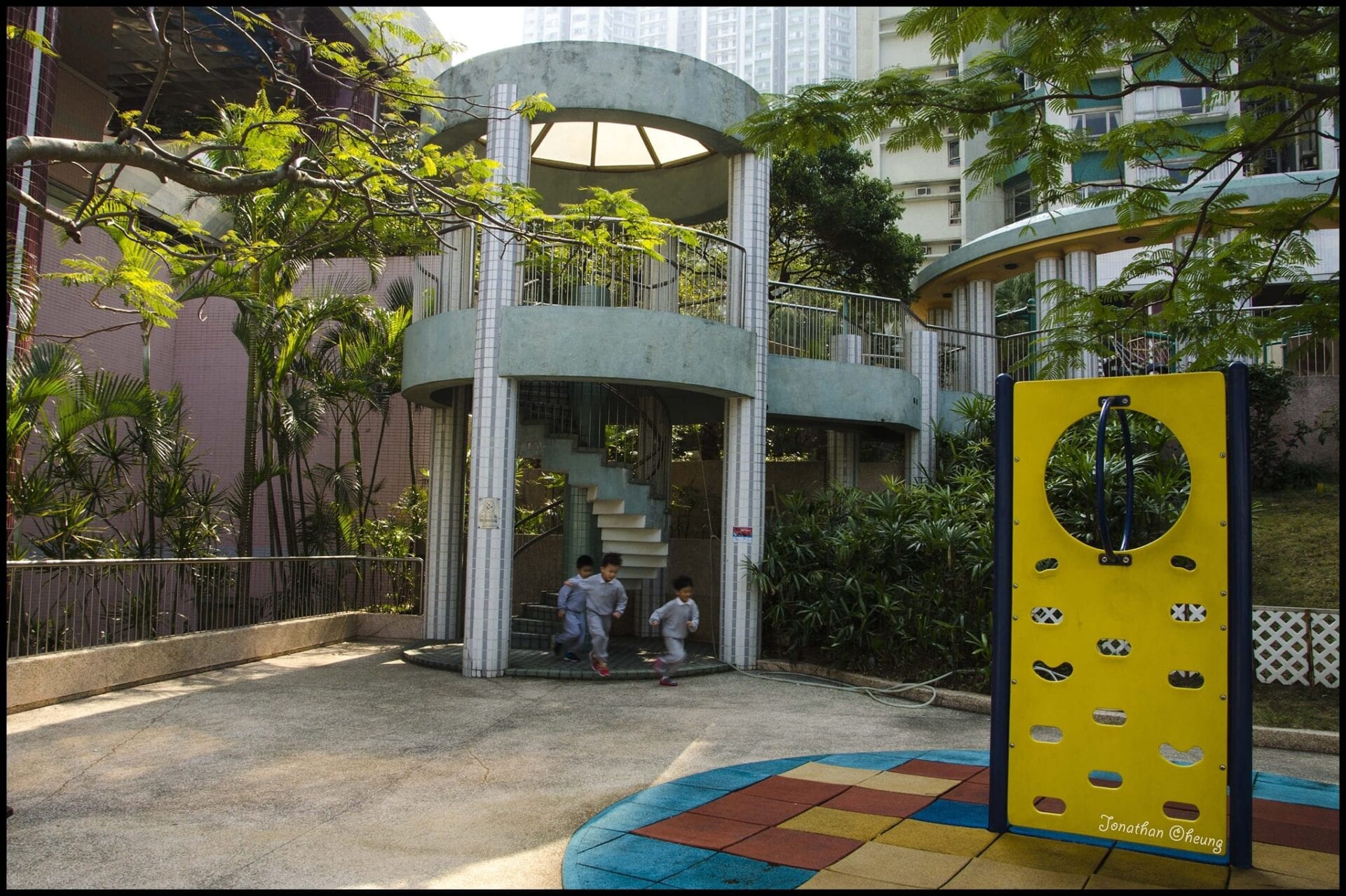 Children in school uniform playing in a small park with excitement, as they race towards the imaginary fort.